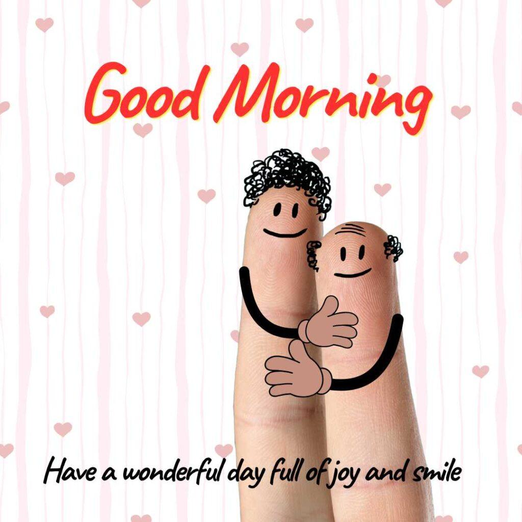 Two finger art characters with drawn smiley faces hugging each other, with "Good Morning" text and a pink heart patterned background.